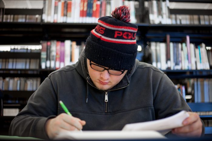 Guy writing a paper in the library