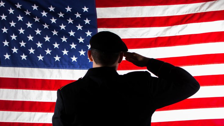 silhouette of soldier saluting American Flag. Photo Credit: Ridgewater Photography Student, Courtney Grammentz