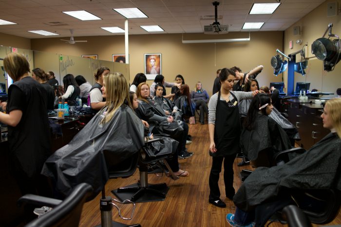 Cosmetology students in the salon cutting hair