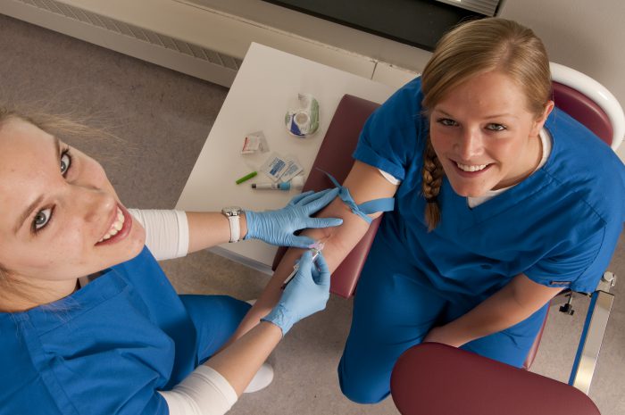 Phlebotomy student drawing blood