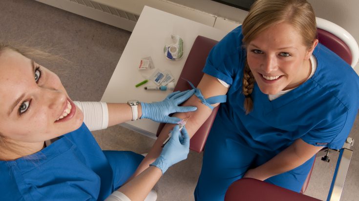 Phlebotomy student drawing blood