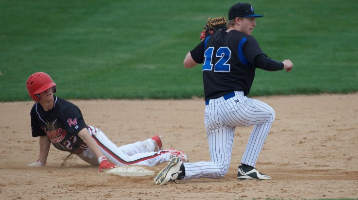 Ridgewater baseball player sliding into base while baseman protects base.