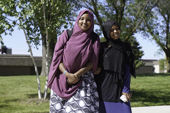 two young women standing outside in front of building