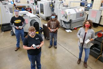 Photo of students and instructors standing in the machine tool lab.