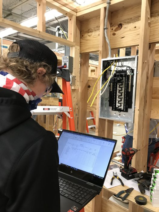 Photo of a student using a laptop to check their electrical setup.
