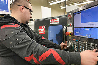 Photo of a student operating a multiaxis lathe